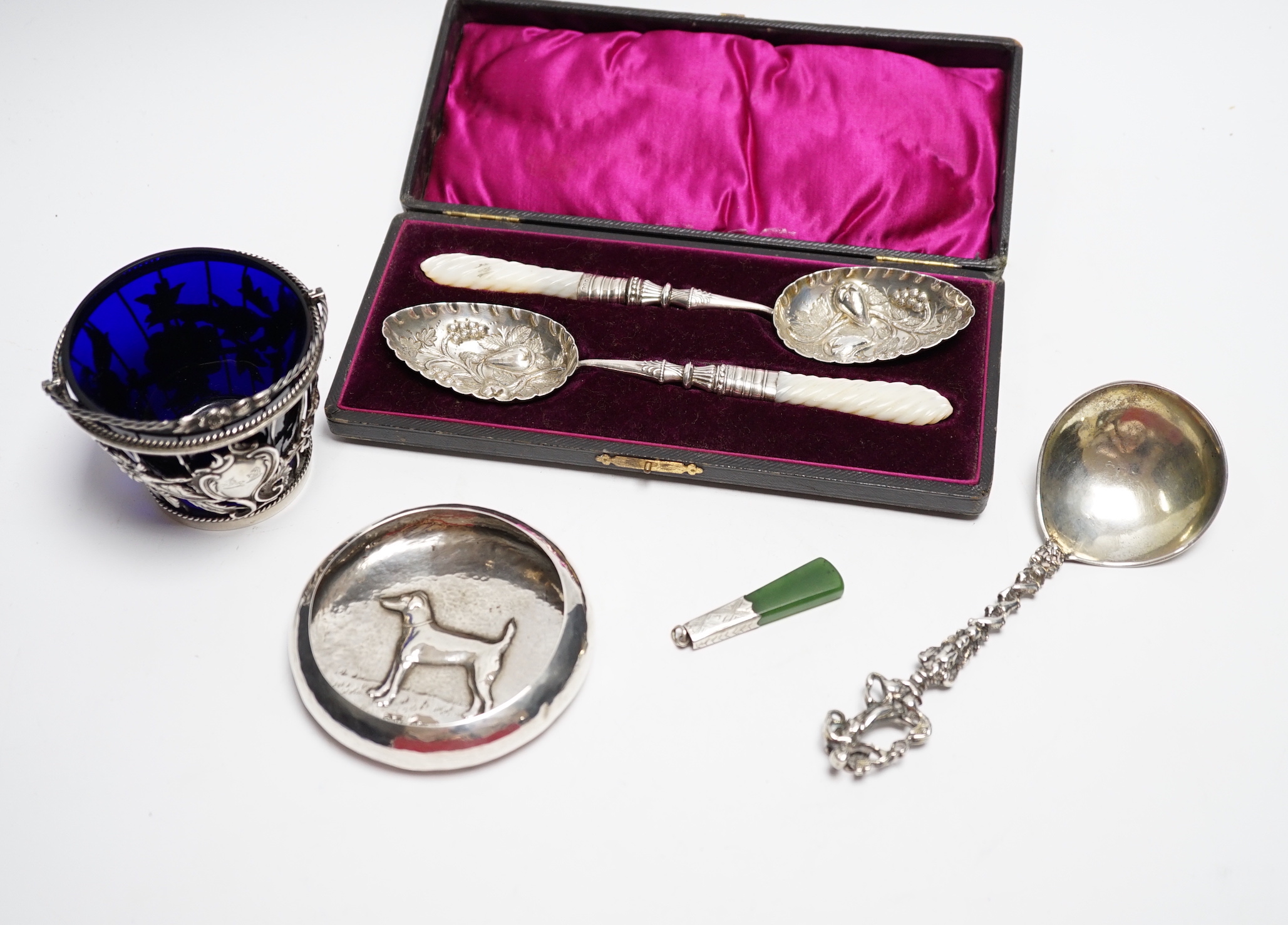 A cased pair of late Victorian mother of pearl handled silver 'berry' spoons, by A.J. Bailey, Birmingham, 1896, a continental white metal spoon with figural terminal, a pierced white metal sugar basket, with blue glass l